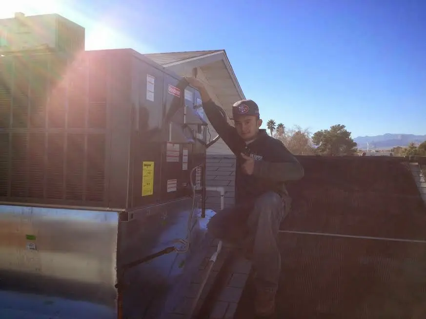 HVAC technician performing AC Tune-Up on a rooftop unit in Carson City